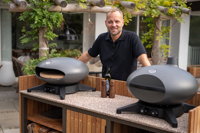 Lasse ved et udendørskøkken med bordplade i StoneCarpet og to pizzaovne