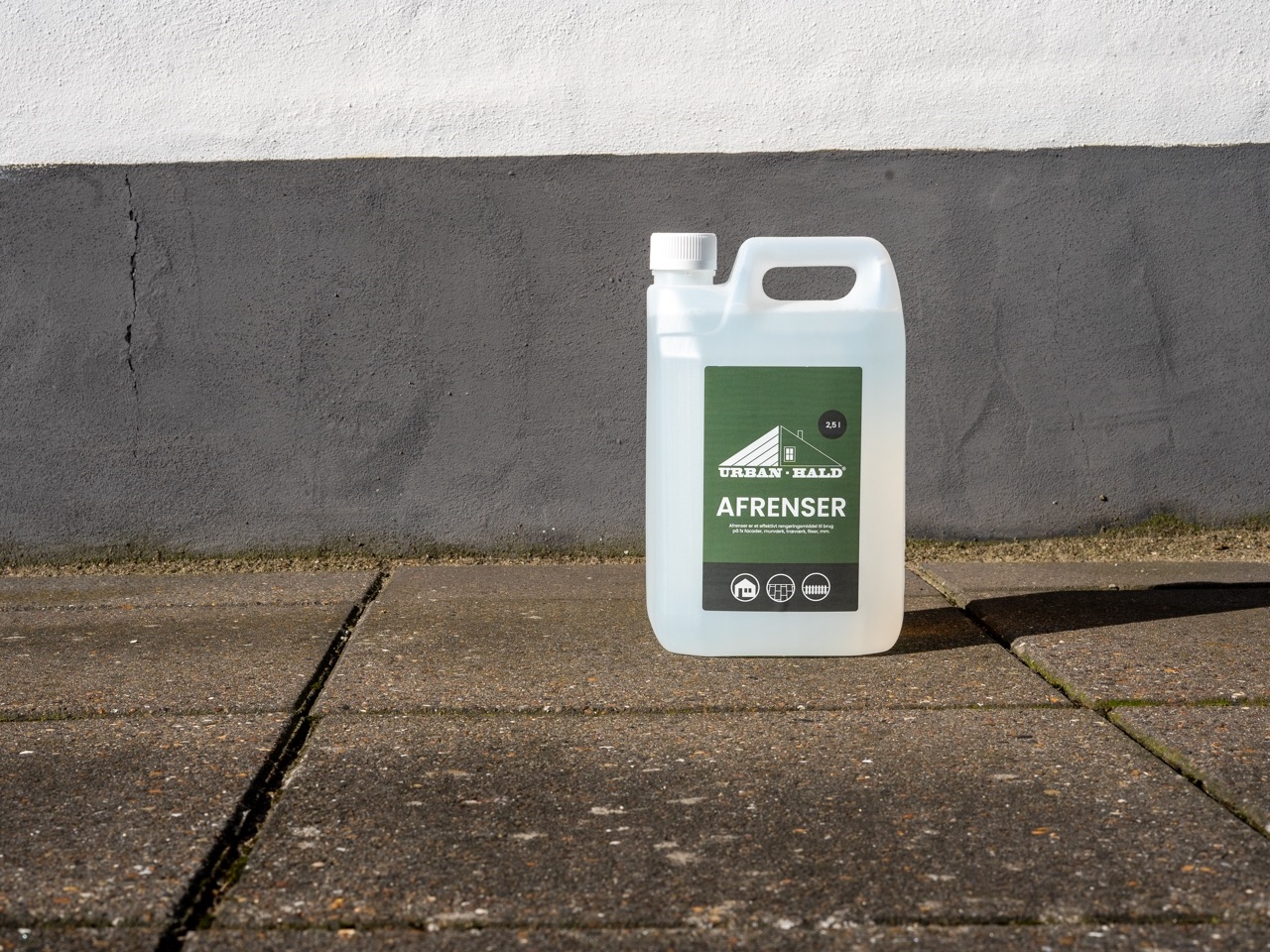 Urban-Hald Afrenser 2,5 liter stående på fliser foran facadesokkel